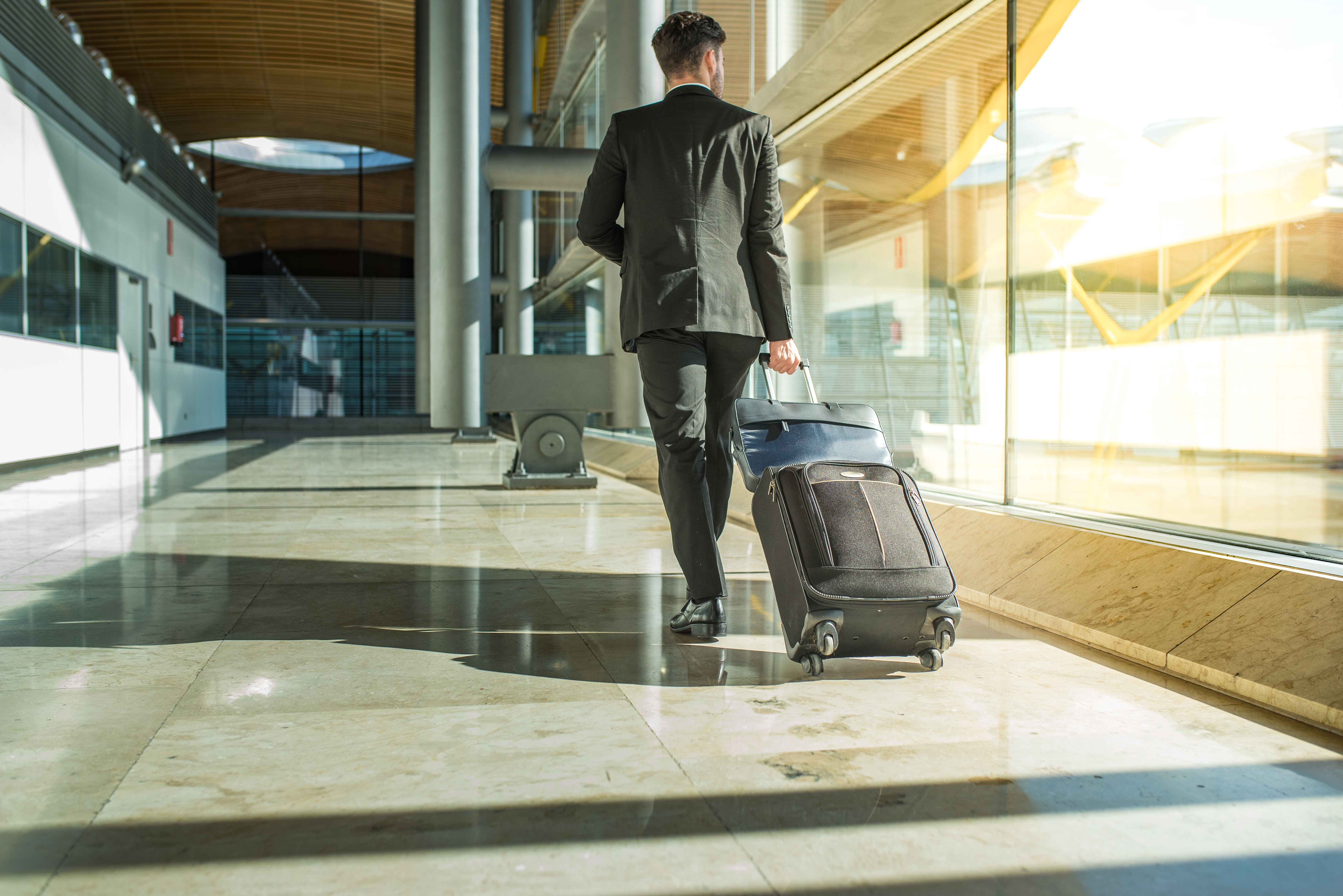imagen de hombre en traje con valija en aeropuerto